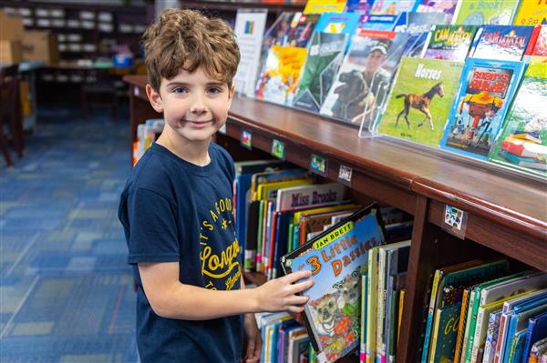 Student checking out a book in the library